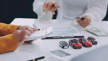 Akıllı telefon ve kredi kartıyla ödeme yapan genç bir kadın.