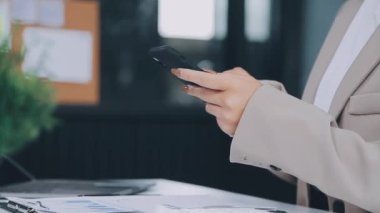 Ofiste otururken akıllı telefon kullanan bir iş kadınını kapat.