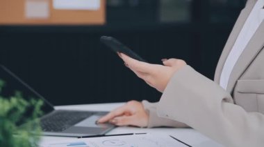 İş adamı masanın üzerinde cep telefonu ve bilgisayar kullanıyor.