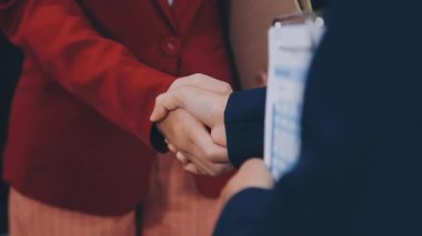 Ofisin arka planında iş adamlarının el sıkışması