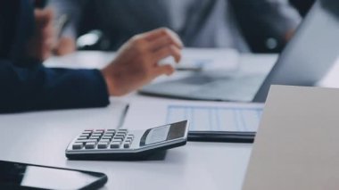 Ofisteki masada hesap makinesi ve hesap makinesi kullanan iş adamı