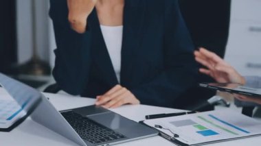 Genç iş kadını ofiste dizüstü bilgisayar kullanıyor.