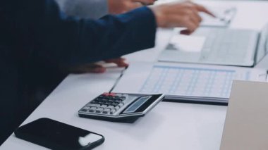 İş adamının el ele tutuşmasını ve hesap makinesine yazmasını kapat