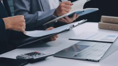 Modern işyerindeki ofis masasında hesap makinesiyle dizüstü bilgisayarda çalışan iş kadını