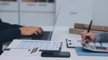 Finans raporunu hesaplamak için hesap makinesi kullanan işadamı