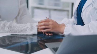 Doktor ve hasta klinikteki masada otururken bir şey tartışıyorlar. sağlık hizmeti kavramı.