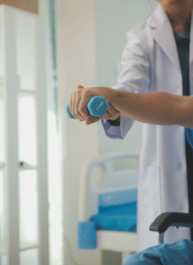 Egzersiz halter tedavi hakkında kol ve omuz sporcu ile erkek hastanın fizik tedavi kavramı veren fizyoterapist adam