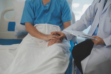 Genç doktor steteskop kullanıyor. Hastanın kalp atışlarını dinle. Kadın bir doktorun erkek bir hastaya muayene yaparken görüntüsü.