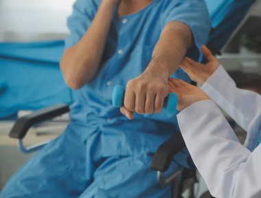 Egzersiz halter tedavi hakkında kol ve omuz sporcu ile erkek hastanın fizik tedavi kavramı veren fizyoterapist adam