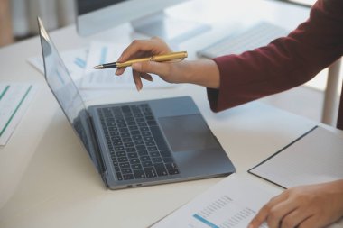 Ofisinde dizüstü bilgisayarla çalışan profesyonel bir iş kadınının görüntüsü. Genç bayan yönetici, modern çatı katında otururken taşınabilir bilgisayar kullanıyor. İşaret fişeği ışığı, iş süreci kavramı.