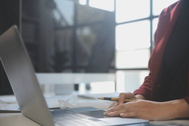 Dizüstü bilgisayarı ve defteri olan genç bir kadın.