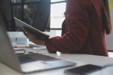 Çağrı merkezinde dost canlısı kadın yardım hattı operatörü. Çağrı merkezinde çalışan ve mikrofonu elleriyle tutan genç bir kadın..