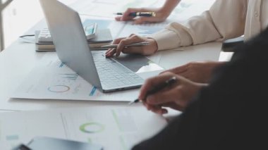 Ofiste dizüstü bilgisayar ve hesap makinesi kullanan bir iş kadını.