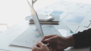 Genç adam dizüstü bilgisayar ve akıllı telefon kullanıyor.