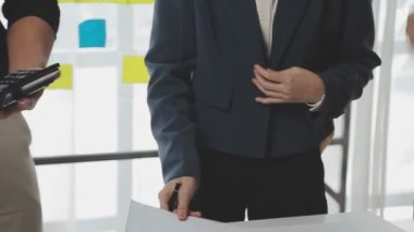 Genç Asyalı iş adamı ofiste kalem tutuyor.