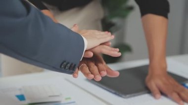 İş arkadaşları el sıkışıyor, ofiste takım çalışması yapılıyor.