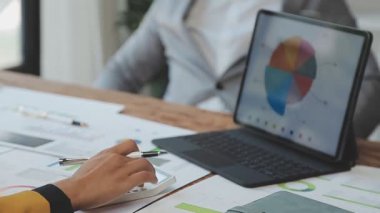 Grafik, mali rapor hesaplamak, veri hesaplamak ve finansal büyüme ve muhasebe için pazarlama planını analiz etmek için hesap makinesi kullanan bir iş adamı.