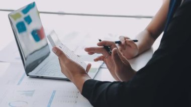 İşadamları laptopta çalışıyor ve ofiste iş planlarını tartışıyorlar.