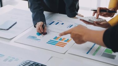 İş adamı ve kadın takımı mali tablolar ve grafikleri tartışıyor