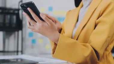 İş yerinde dizüstü bilgisayar ve telefon kullanan iş kadını