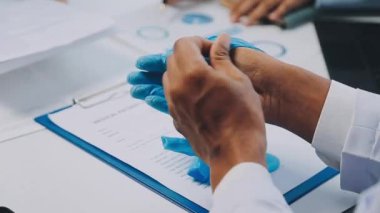 Elinde kalemle pano tutan erkek doktorun kırpılmış görüntüsü.
