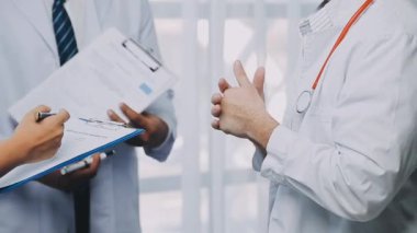 Kağıda bir şeyler yazmak için elinde kalem tutan doktoru kapat.