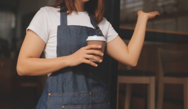 Başlangıçta başarılı olan küçük işletme sahibi, kafeterya restoranında elinde tablet akıllı telefonuyla güzellik kızı standı açmıştı. Kahveci Asyalı kadının portresi. KOBİ girişimci iş konsepti