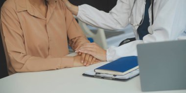 Doktorun eli kadın hastasına güvence veriyor.