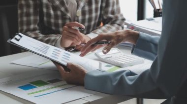 İş ekibi ofisteki bilgisayarda mali verileri tartışıyor ve tartışıyor..