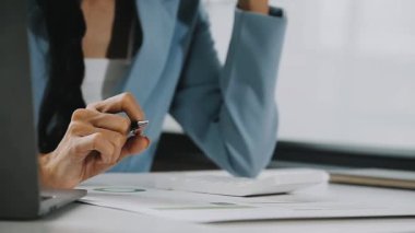 Bilgisayarlı genç bir kadın ve ofiste bir fincan kahve.