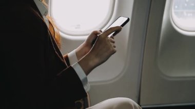 Akıllı telefon tutan ve pencerede mesaj okuyan bir kadın.