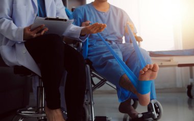 Parlak ofisteki hastayla tedavi gören bir fizyoterapist