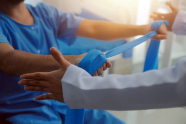 Egzersiz halter tedavi hakkında kol ve omuz sporcu ile erkek hastanın fizik tedavi kavramı veren fizyoterapist adam