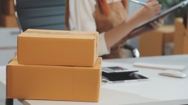 Genç bir kadın küçük bir iş paketi üzerinde çalışıyor, online dağıtım konsepti, çevrimiçi servis.