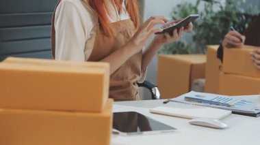 Modern bir ofiste dizüstü bilgisayarla tablet bilgisayarda çalışan bir kadın..