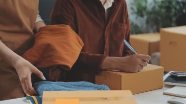 Asyalı girişimci bir ürünü teslim etmek için paket kutusu hazırlıyor.