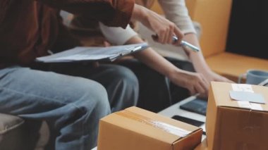 Karton kutuları ve bilgisayarı olan kadın teslimat merkezinde.