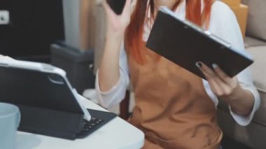 Asyalı iş adamı dijital tablet kullanıyor ve defterini ofisinde tutuyor.