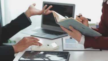 Akıllı telefonlu bir iş kadını dizüstü bilgisayarla çalışıyor.