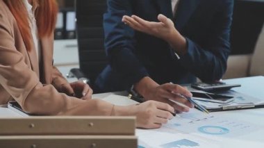 Bilgisayarla çalışan iş adamları ve iş planlarını ofiste tartışırlar.