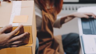 Teslimatçı elinde kartonla paket kutusu tutuyor.