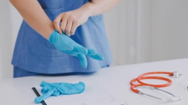 Elinde steteskopla mavi üniformalı bir doktor..