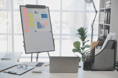 Çalışma odasındaki toplantı masasında kapağı açık dizüstü bilgisayar.