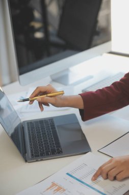 Ofisinde dizüstü bilgisayarla çalışan profesyonel bir iş kadınının görüntüsü. Genç bayan yönetici, modern çatı katında otururken taşınabilir bilgisayar kullanıyor. İşaret fişeği ışığı, iş süreci kavramı.
