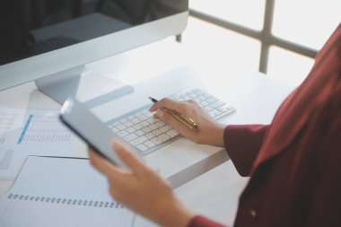 Ofisteki resmi takım elbiseli Asyalı iş kadını akıllı telefon ve çalışma süresince mutlu ve neşeli.