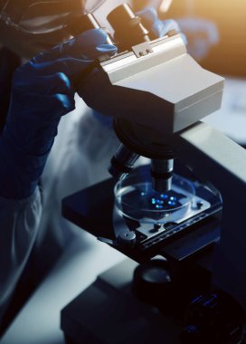 Bilimsel araştırmalar için bilimsel mikroskop kullanan profesyonel kimyager kadın laboratuvarı, mikrobiyoloji medikal ekipman teknolojisi ile çalışan kimya bilimcisi tıp biyolojisi deneyi için çalışan