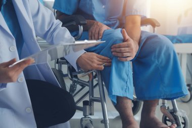 young asian physical therapist working with senior woman on walking with a walker