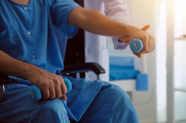 Egzersiz halter tedavi hakkında kol ve omuz sporcu ile erkek hastanın fizik tedavi kavramı veren fizyoterapist adam