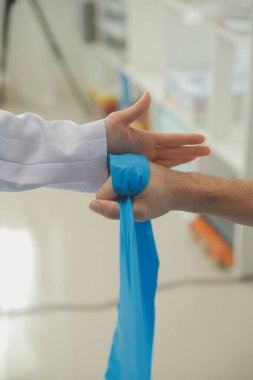 Egzersiz halter tedavi hakkında kol ve omuz sporcu ile erkek hastanın fizik tedavi kavramı veren fizyoterapist adam