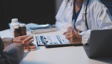 Diş sağlığı kliniğinde planlı diş tedavisi hakkında dişçi ve hasta tartışması, doktorlar konuşur ve çalışır. Sağlık Bakanlığı Tıp Konferansı Konsepti